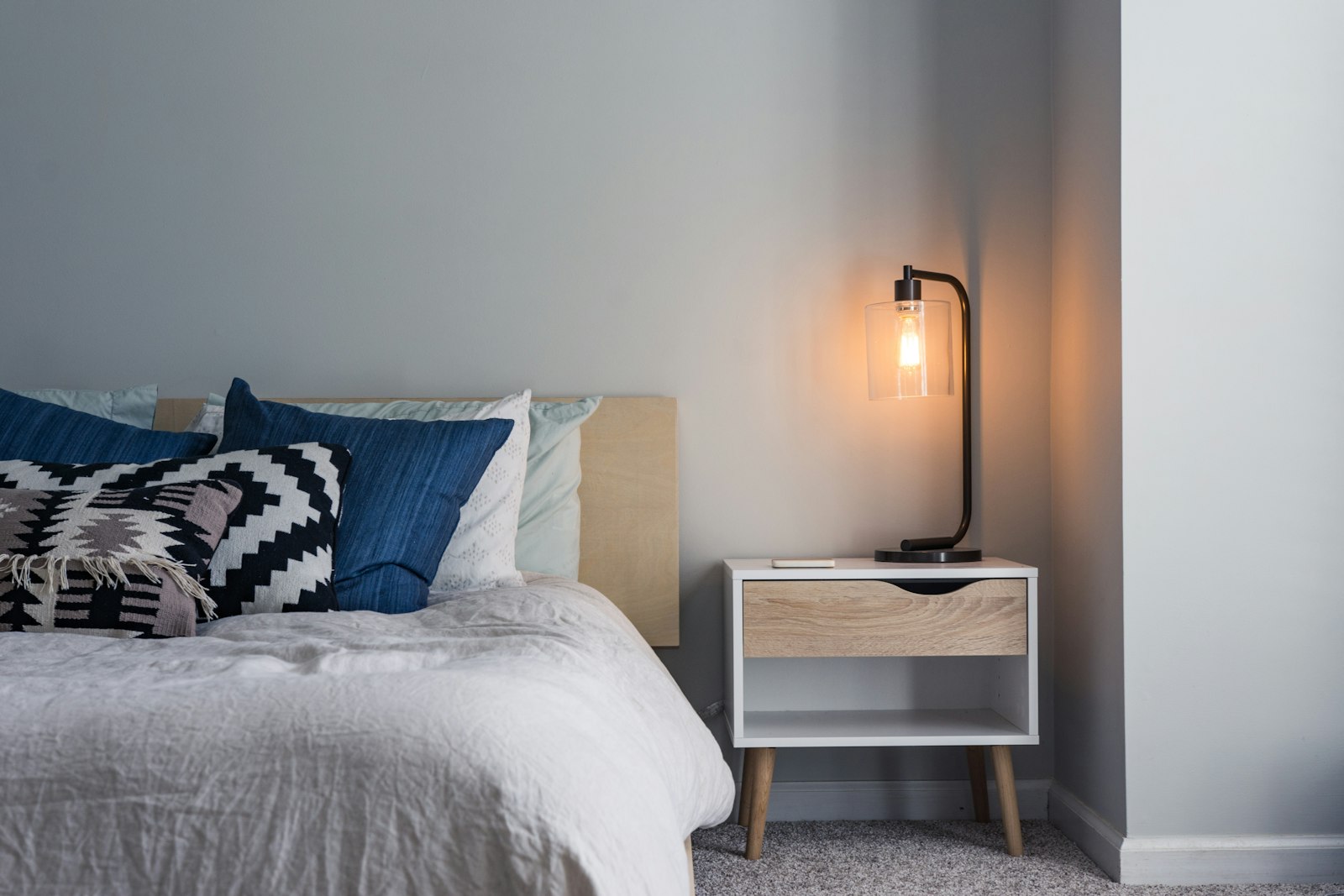 A calm hotel room with soft linens and a bedside lamp (placeholder photo)